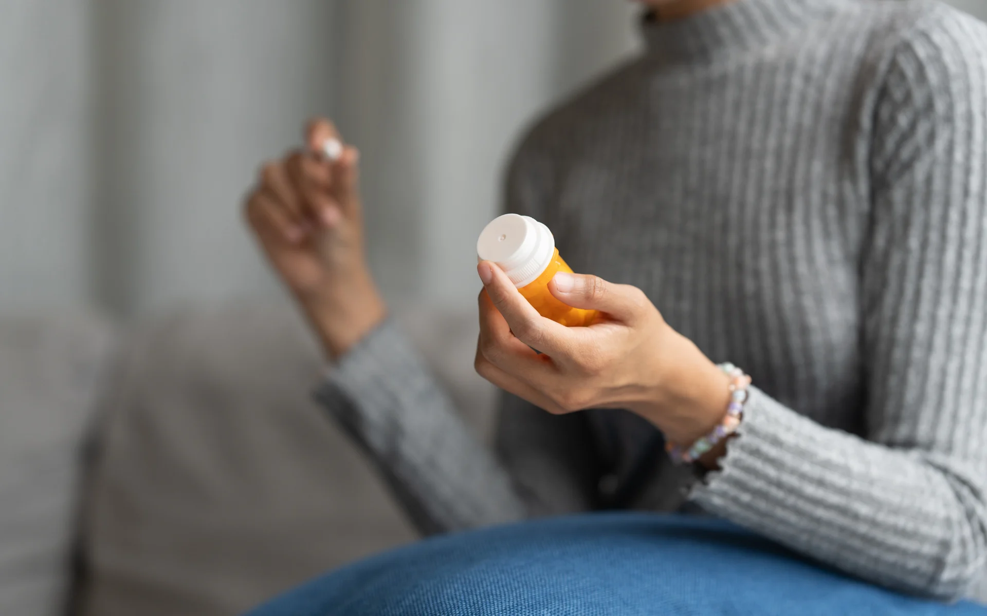 Pessoa segurando frasco de medicamento